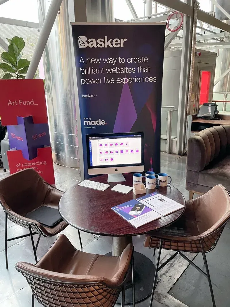 Basker stand with a laptop, chairs, and display banners at AMA Digital Marketing Day 2024.