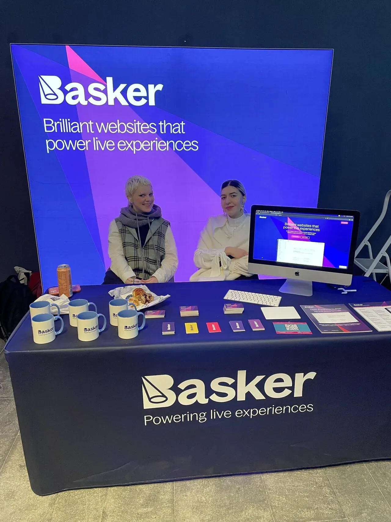 Basker exhibition stand with two team members and demo materials at AMA Digital Marketing Day 2025.