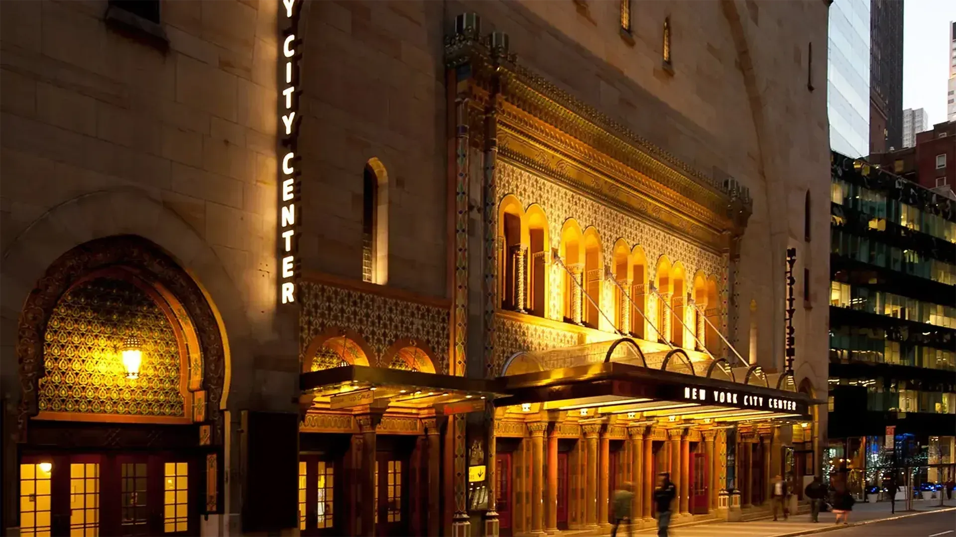 The illuminated New York City Center entrance and marquee at night.